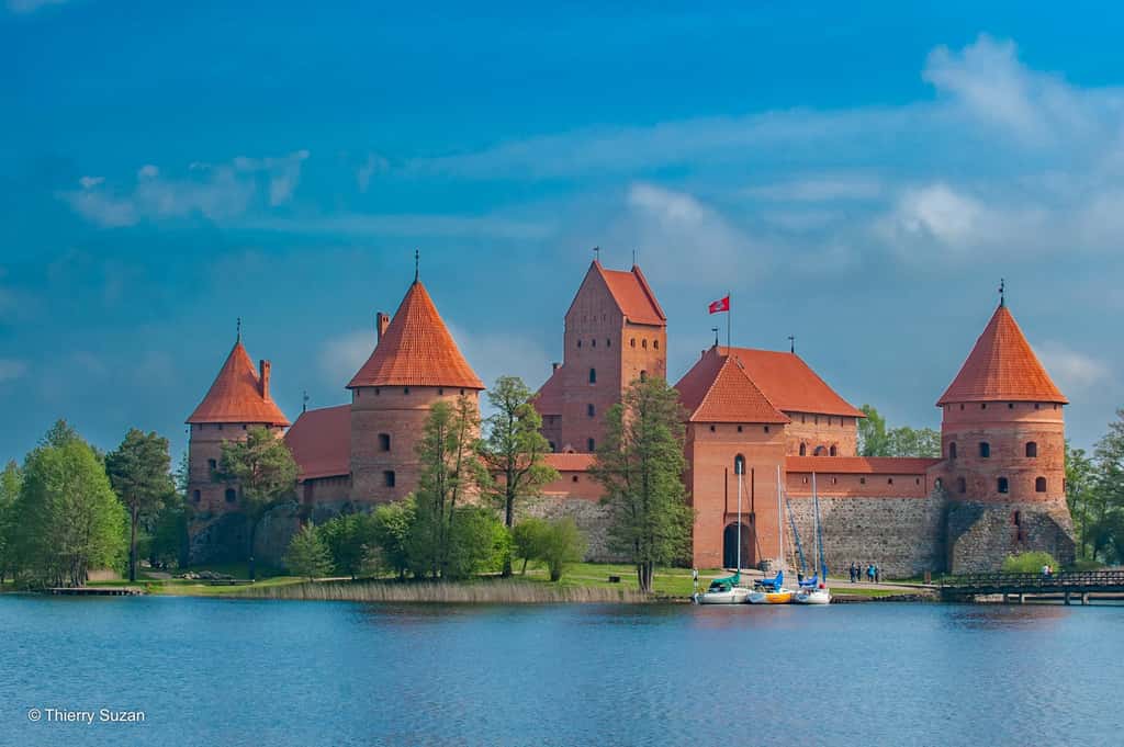Reflet d’un passé glorieux, le château de Trakai trône sur son île, mêlant beauté architecturale et sérénité naturelle. Témoignage vivant de l’histoire médiévale du pays, ce joyau gothique de briques rouges semble flotter sur l’eau, comme figé dans le temps. Château de Trakai © Thierry Suzan – Tous droits réservés